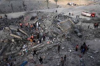 Палестинцы разбирают завалы после израильских ударов по Рафаху на юге сектора Газа, 22 ноября 2023 года