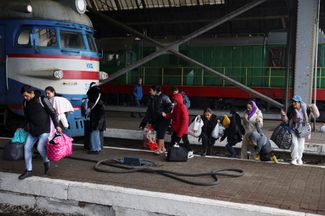 People at the Lviv train station boarding a train to Poland