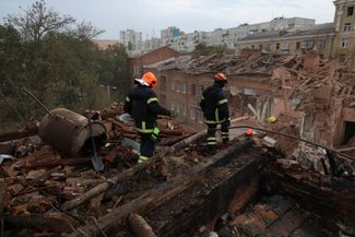 Спасатели на крыше поврежденного ударом здания