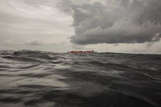 Беженцы и мигранты ждут спасателей в 60 милях от берегов Ливии. 18 февраля 2018 года.