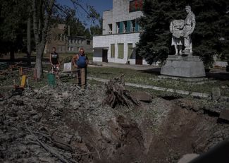 Воронка от снаряда на месте детской площадки в Дружковке