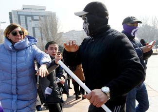 Мужчина в маске нападает на активистку на марше солидарности. Бишкек, 8 марта 2020 года
