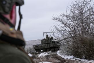 Бойцы ВСУ едут на танке Т-64 на своих позициях под Бахмутом