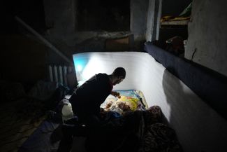 Мужчина играет со своим ребенком в подвале дома. Мариуполь, 6 марта 2022 года