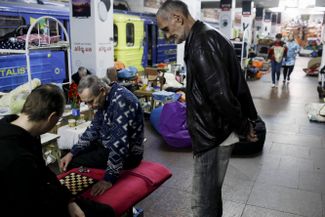 Мужчины играют в шашки в метро