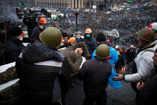 Участники «Евромайдана» несут раненного протестующего. Киев, 20 февраля 2014-го