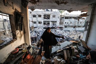 Женщина осматривает разрушенное здание в Рафахе на юге сектора Газа. 19 декабря 2023 года
