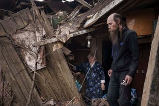 Жители Харькова возле своего дома, разрушенного в результате обстрелов