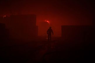 Пожарный работает на месте возгорания, возникшего в результате российского обстрела