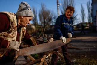 Жительницы Херсонской области Надежда и Наталья пилят дрова на растопку