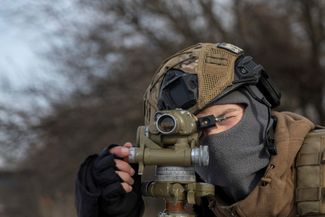 Украинский военнослужащий смотрит в дальномер