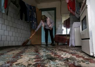 Жительница Павлограда прибирается в своем доме после российского обстрела