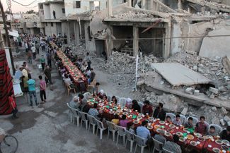 Сирийские мусульмане принимают пищу после вечерней молитвы во время Рамадана. Дамаск, 18 июня