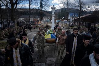 Украинские военные несут гроб с останками своего сослуживца Василия Бойчука, погибшего в Николаеве в марте 2022 года. Его похороны состоялись 26 декабря 2023 года. 