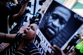 Демонстранты несут плакаты с портретом Джорджа Флойда, 46-летнего американца, убитого полицейскими Миннеаполиса при задержании. Миннеаполис, штат Миннесота, 28 мая 2020 года