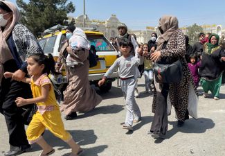 Женщины с детьми пытаются попасть в аэропорт Кабула. 16 августа 2021 года