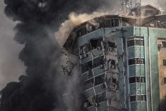 Многоэтажное здание в Газе, в котором находились бюро Associated Press и «Аль-Джазиры», разрушается в результате авиаудара израильских самолетов, 15 мая 2021 года
