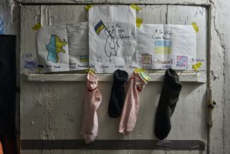 Носки для подарков, закрепленные на стенде с детскими рисунками на военной базе ВСУ под Бахмутом
