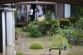Затопленный двор дома в городе Дзесо в префектуре Ибараки, 10 сентября 2015 года