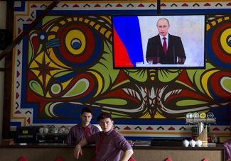 Сотрудники пиццерии в Симферополе смотрят послание Владимира Путина к членам Федерального собрания и другим официальным лицам по вопросу присоединения Крыма, 18 марта 2014 года