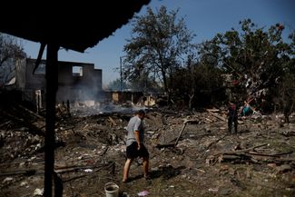 Местный житель на развалинах дома, разрушенного в результате российского обстрела. 