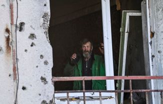 Житель Граково внутри поврежденного обстрелами здания