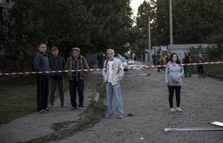 Жители Харькова осматривают место российского авиаудара
