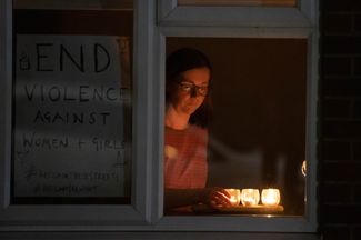 В Клэпхэме, как и по всей Великобритании (на фото жительница Бирмингема), зажгли свечи и фонарики в 21:30 — в то время, когда Сару Эверард последний раз видели живой