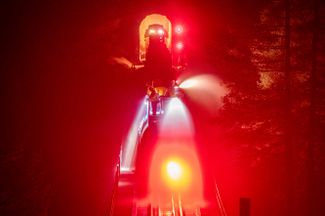 Пожарный поезд разбрызгивает воду на очаг возгорания в округе Плюмас, 26 июля 2021 года