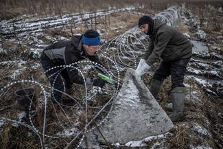 Украинские рабочие устанавливают заграждения на линии фронта в Харьковской области, 25 декабря 2023 года