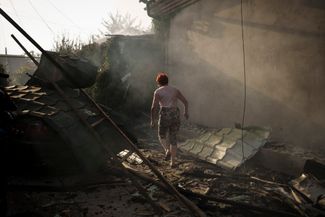 Женщина вышла из своего горящего дома после российской атаки города