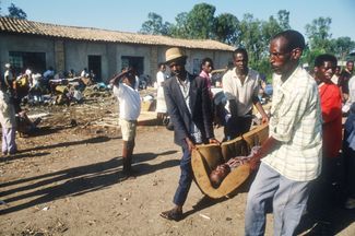 Тело погибшего тутси несут на похороны. 25 мая 1994 года