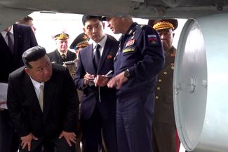 Ким Чен Ын (слева) осматривает российский военный самолет во время посещения аэродрома Кневичи, 16 сентября 2023 года