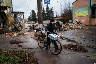 Житель Бахмута идет рядом со своим велосипедом по городским улицам, перегороженным противотанковыми ежами. От довоенного населения 70 тысяч человек сейчас в осажденном Бахмуте осталось несколько тысяч жителей, в основном пенсионного возраста