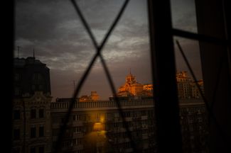 Закат в Киеве, снятый через окно квартиры. Оно заклеено на случай взрыва — это поможет избежать ранений от разлетающихся осколков. 28 февраля 2022 года