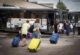 Эвакуированные направляются к автобусам, которые отвезут их из Курска в Подмосковье. 9 августа 2024 года