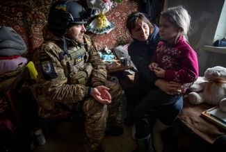 Бахмутский полицейский уговаривает местную жительницу Ольгу и ее шестилетнюю внучку Арину эвакуироваться из города