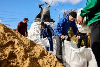 Рабочие набирают в мешки песок, чтобы обложить ими памятник Героям Небесной сотни в Николаеве. Небесной сотней в Украине называют погибших во время Евромайдана в декабре 2013 — феврале 2014 года