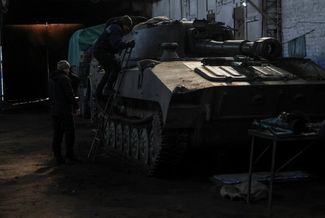 Украинский механик осматривает самоходную гаубицу перед ремонтом