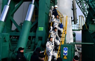 Космонавт «Роскосмоса» Александр Мисуркин (в центре на первом плане), японский космический турист Юсаку Маэдзава (в центре на втором плане) и Едзо Хирано (в центре на третьем плане) перед запуском ракеты-носителя «Союз-2.1а» на МКС. Байконур, 8 декабря 2021 года
