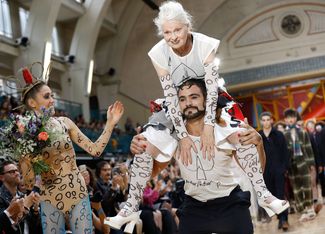 Вивьен Вествуд на плечах модели на показе своей коллекции во время недели мужской моды в Лондоне. Июнь 2017 года
