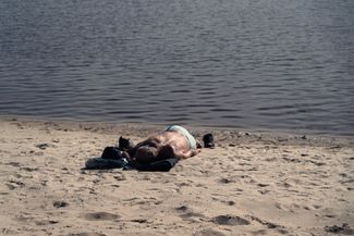 A Zaporizhzhia resident sunbathes on an exposed shoal