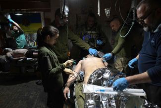 Украинские военные врачи оперируют раненого бойца ВСУ в пункте стабилизации