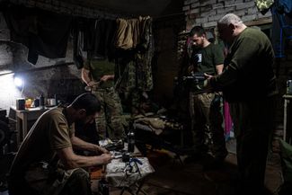 Военные Украинской добровольческой армии — подразделения, созданного на базе движения «Правый сектор», — готовят к бою оружие в подвале лагеря под Угледаром