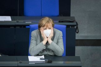 Пандемия стала одновременно и политическим триумфом, и тяжелым испытанием для Меркель. В первые месяцы немцы поддержали жесткие ограничения, вводимые правительством одновременно с мерами по поддержке экономики, и в этот период многие политики даже заговорили, что Меркель должна отказаться от своего намерения уйти в отставку и пойти на пятый срок. Но с началом кампании по вакцинации и постепенным снятием ограничений критики стало значительно больше. Сама Меркель до сих пор в любом закрытом помещении всегда появляется в маске, как на этой фотографии, сделанной во время заседания бундестага 13 января 2021 года.