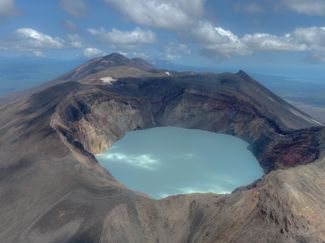 Озеро в кратере вулкана Малый Семячик. Его облетает вертолет во время экскурсии в Долину гейзеров