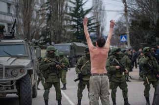 Безоружный мужчина встал перед российскими военными без опознавательных знаков в знак протеста против их действий. Балаклава, Крым, 1 марта 2014 года