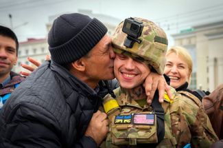 Житель Херсона целует украинского военного во время празднования освобождения города