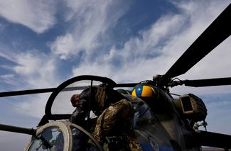Пилот вертолета из 18-й бригады ВСУ проверяет машину после возвращения с боевой миссии на линии фронта