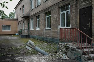 An undetonated shell next to the black door of a kindergarten in Lysychansk